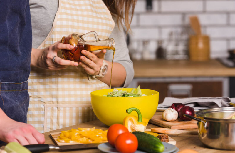 Renkli salata üzerine dökülen taze hazırlanmış salata sosu